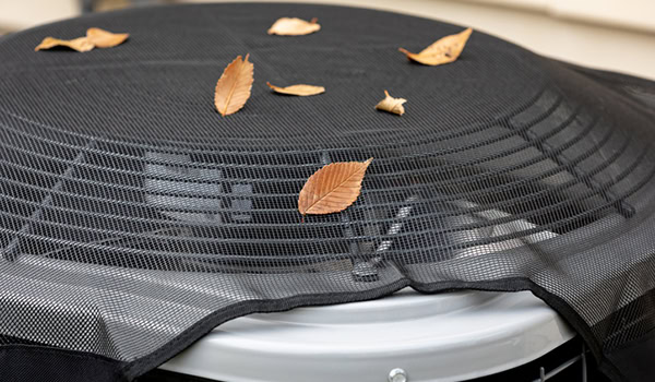 Air conditioning unit with a protective cover to keep leaves out.